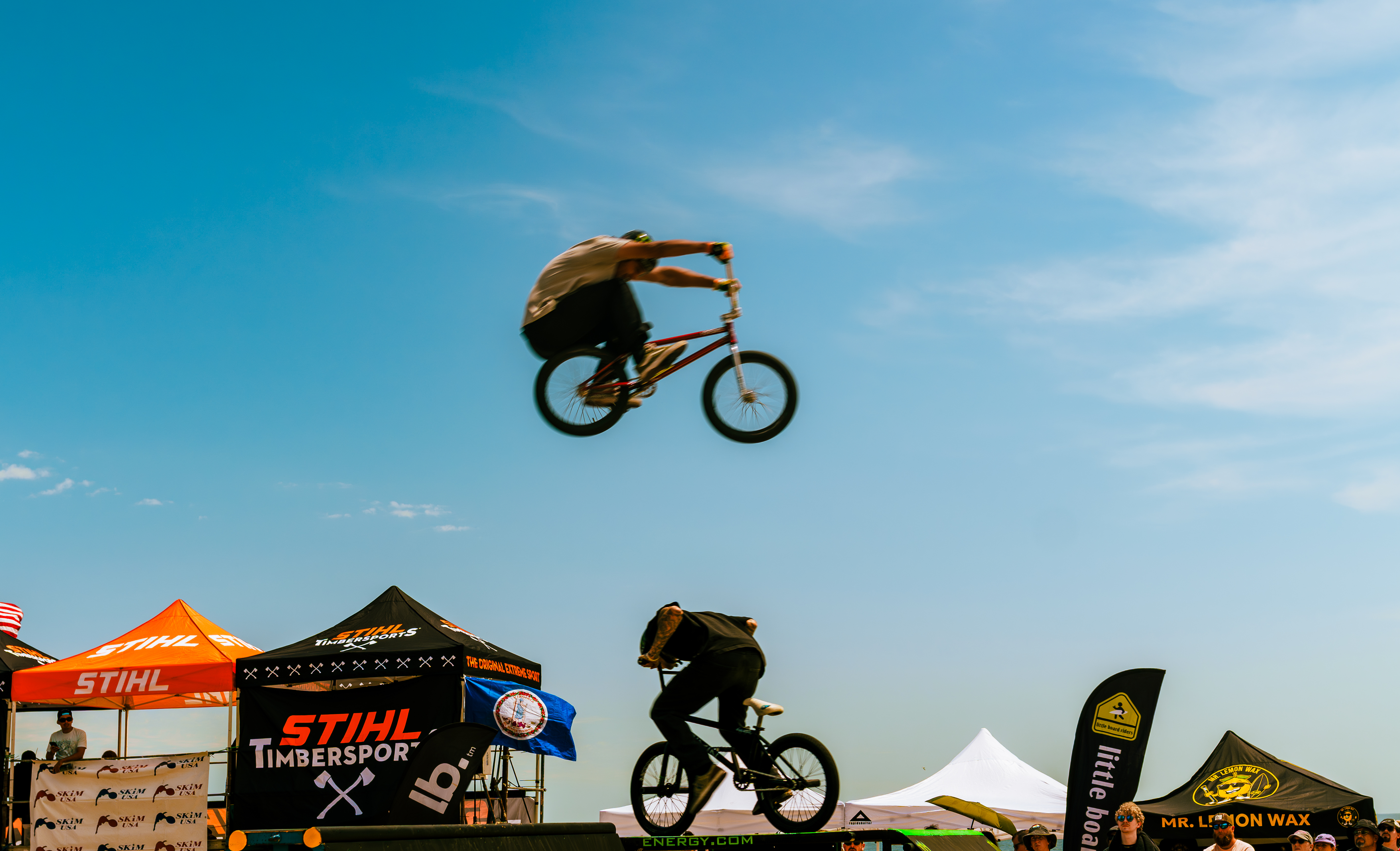 BMX rider going over another bmx rider